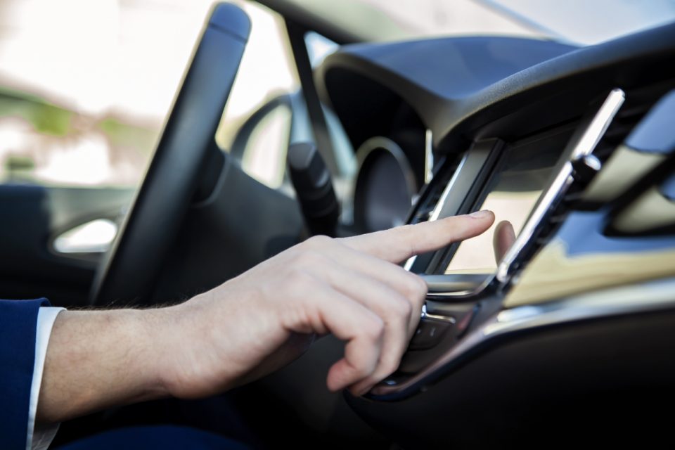 Man hand touching the LCD screen in the car