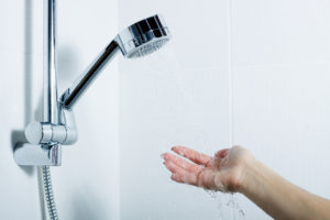 Woman testing temperature of shower water