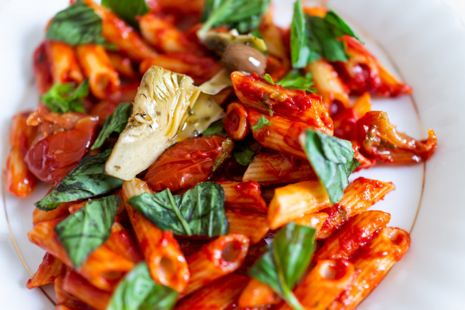 Fresh vibrant red tomato sauce on penne pasta.