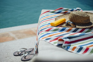 Woman's hat and towel sitting by the pool