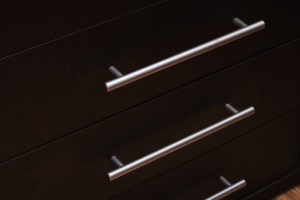 Wooden drawer shelves with metal handles closeup