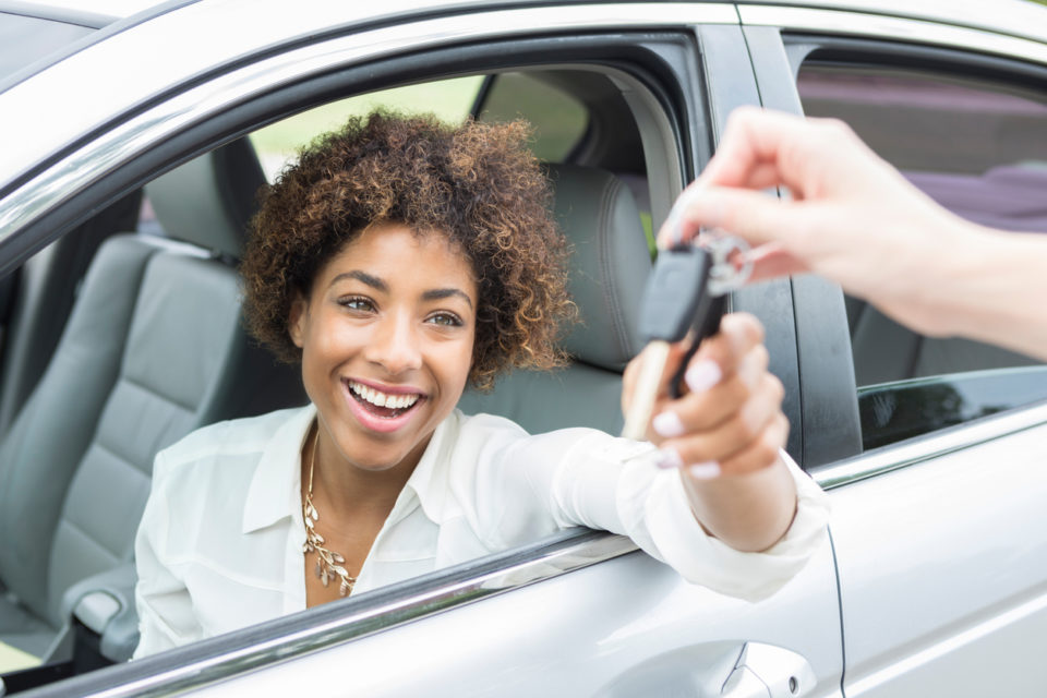 Excited young woman accepts new car keys