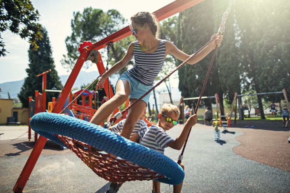 Kids swinging together on a big swing