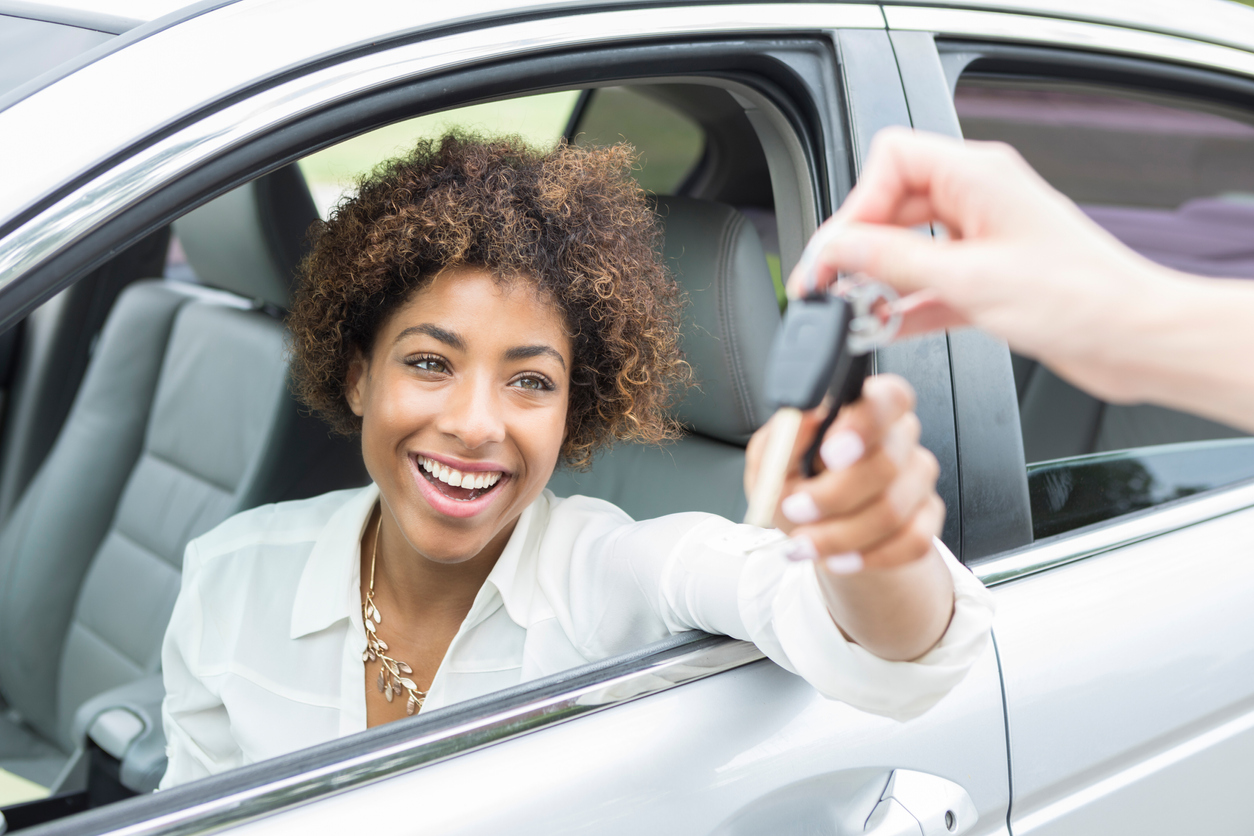 Excited young woman accepts new car keys