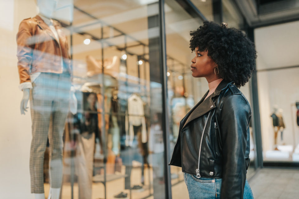 Woman standing in front of clothing display in the mall