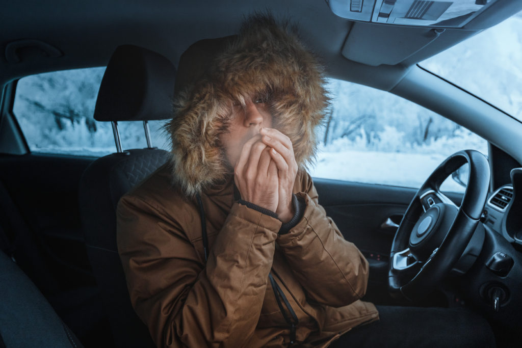 driver tries to keep warm in a cold car