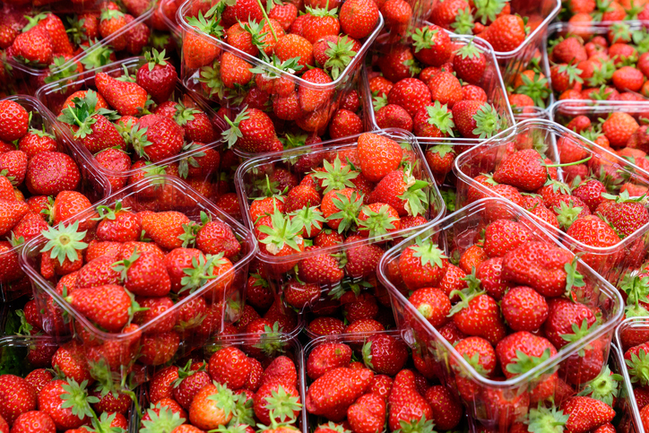 Transparent plastic boxes with fresh organic strawberries in display at a street food market