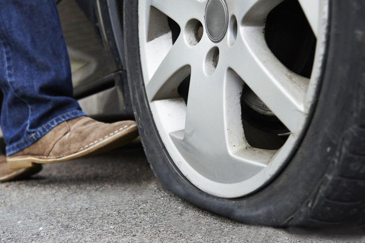 Motorist Kicking Flat Tire On Car